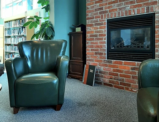 leather recliner sitting beside fireplace inside Flesherton library