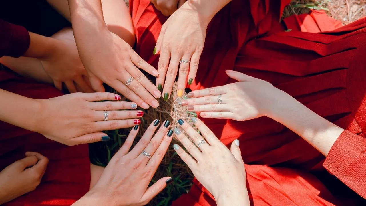 A circle of diverse women's hands, symbolizing unity and collaboration.