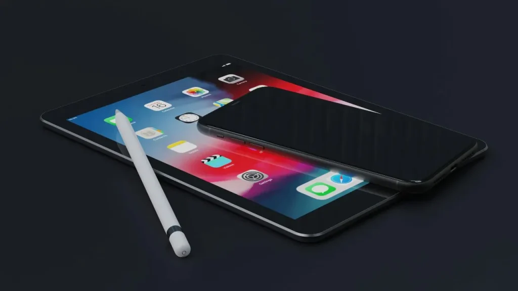 A tablet displays a colorful home screen under a black smartphone; a white stylus lies beside them on a dark surface, conveying a tech-savvy vibe.